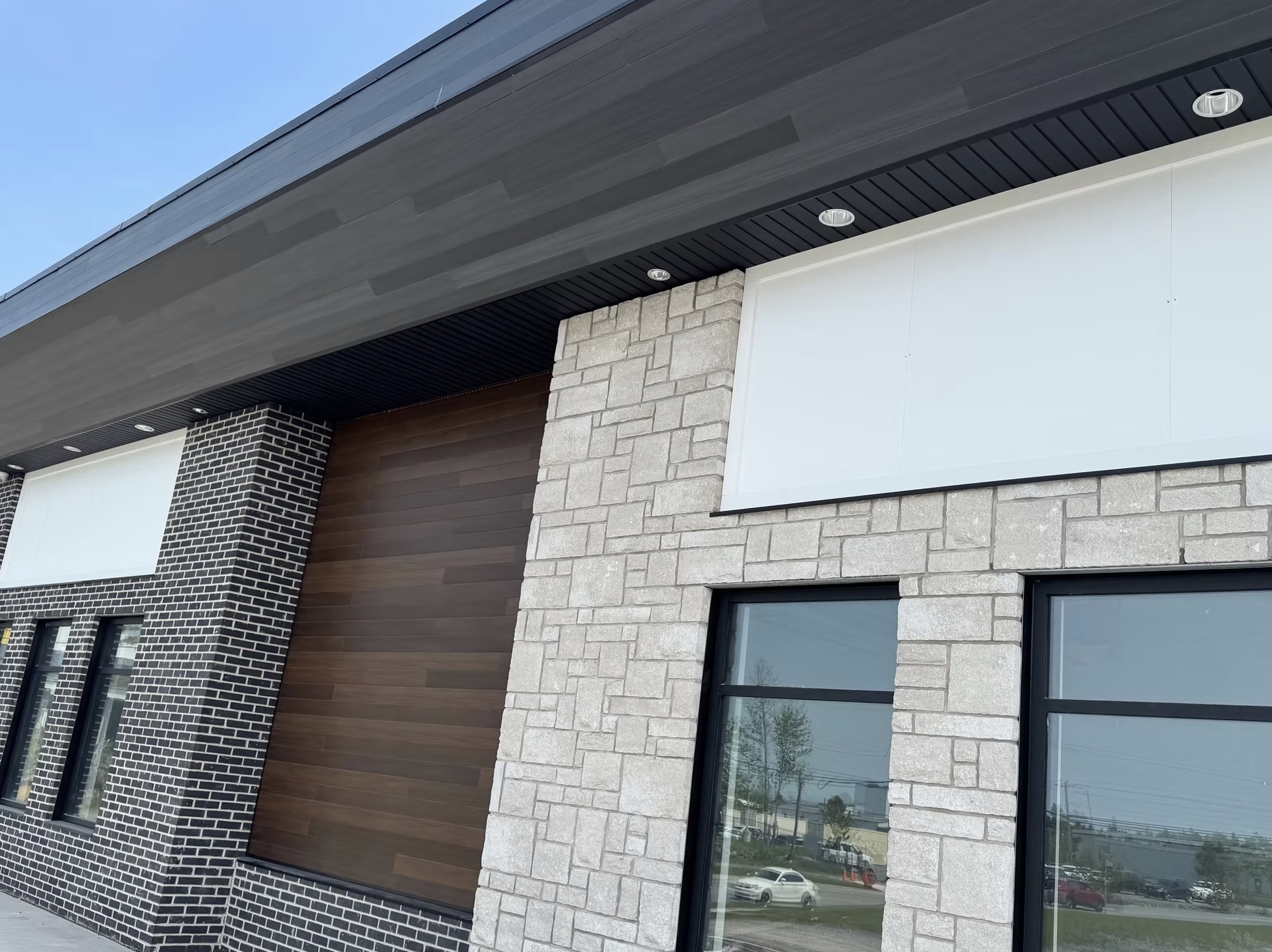 Modern building exterior with light stone cladding, dark — European window and door project, Vireo Homes GTA