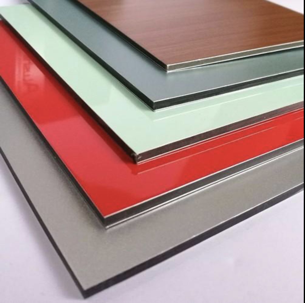 Stack of colorful aluminum composite panels: wood, green, grey, red, — Vireo Homes exterior cladding systems