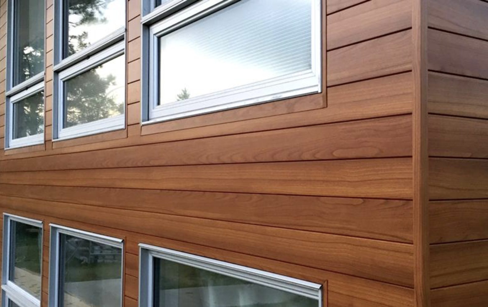 Building exterior with horizontal wood-grain siding and multiple — Vireo Homes exterior cladding systems