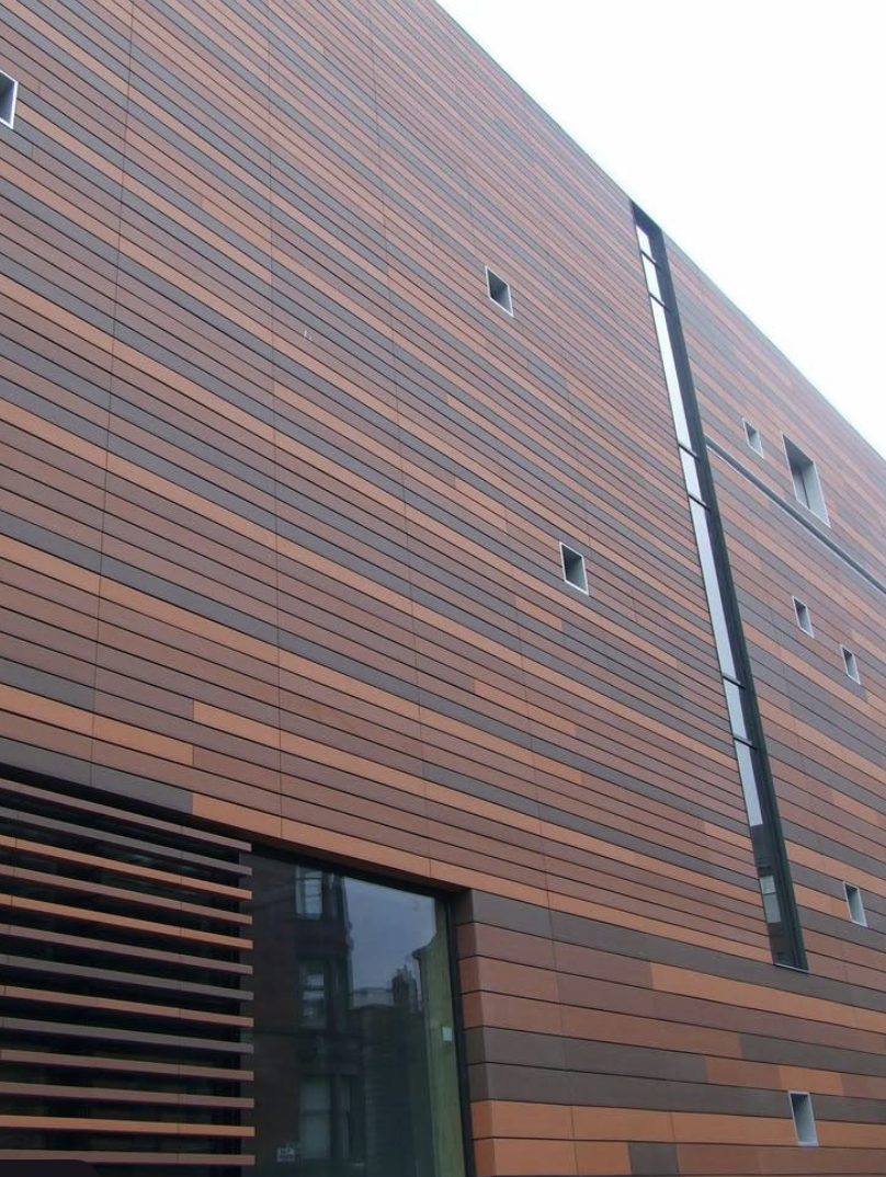 Building facade with horizontal striped panels in varying shades of — Vireo Homes exterior cladding systems