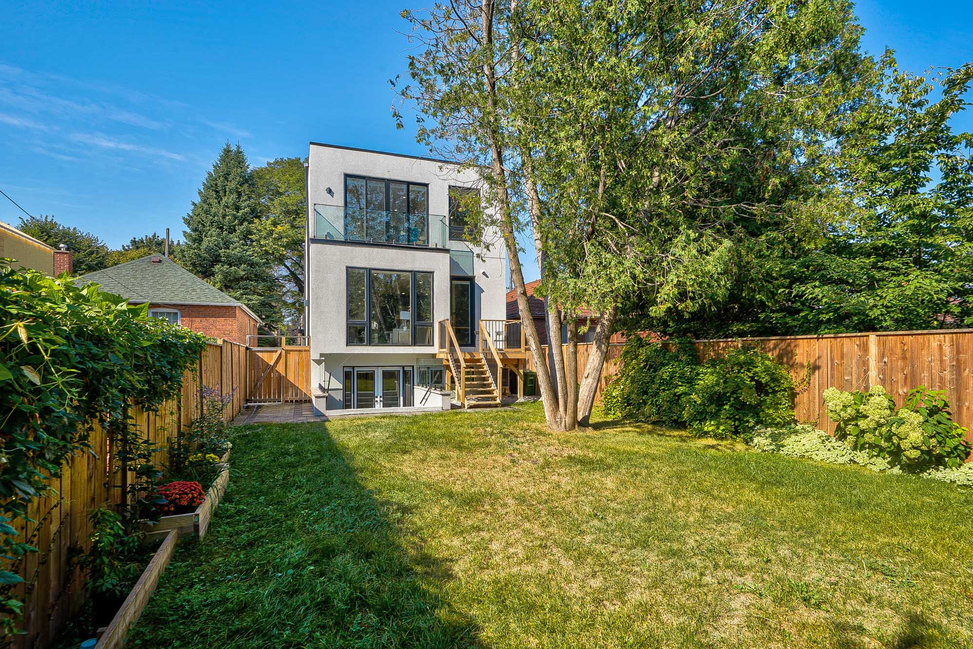 Modern white stucco house with glass balconies and dark — European window and door project, Vireo Homes GTA